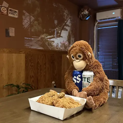치킨과 맥주 캔을 끌어안고 앉은 다락방 오랑우탄 인형